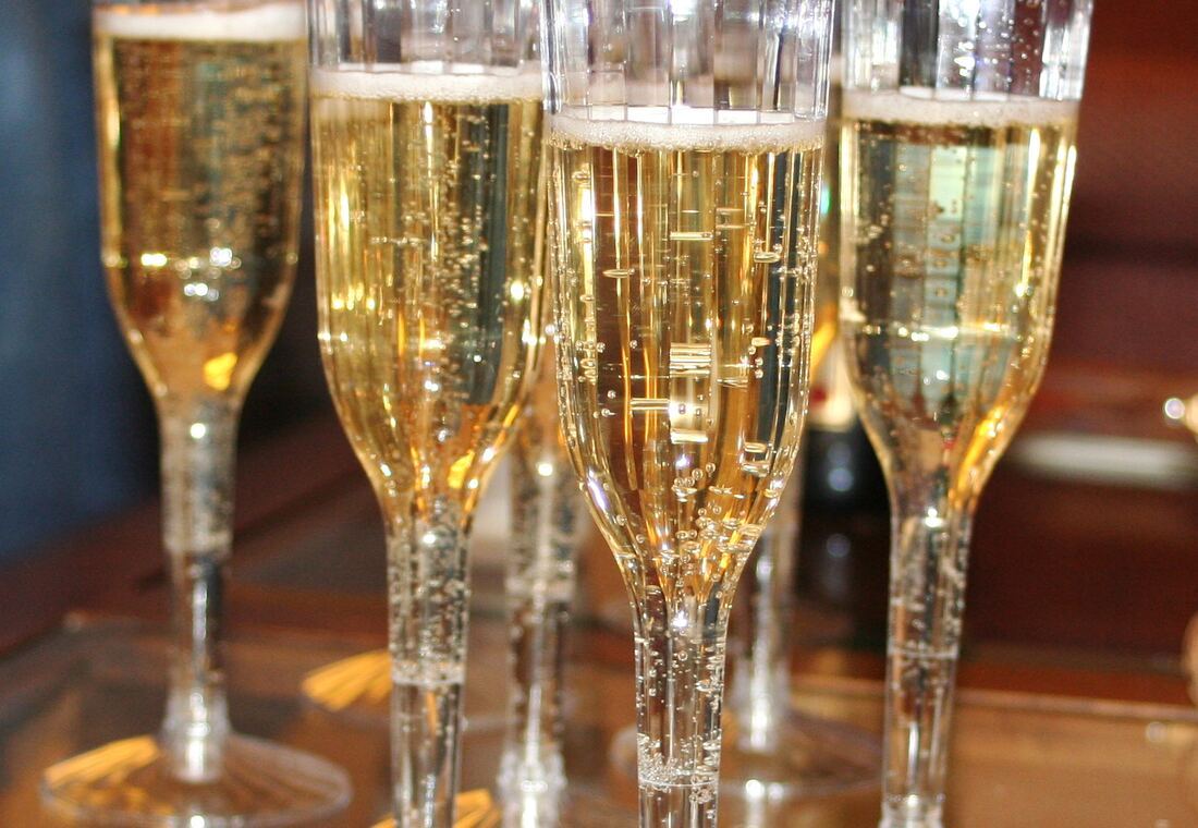 Un plateau de coupes de champagne remplies, en lumière chaude.